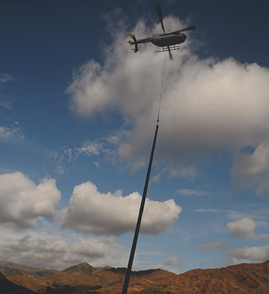Helicóptero transportando poste de fibra de vidrio